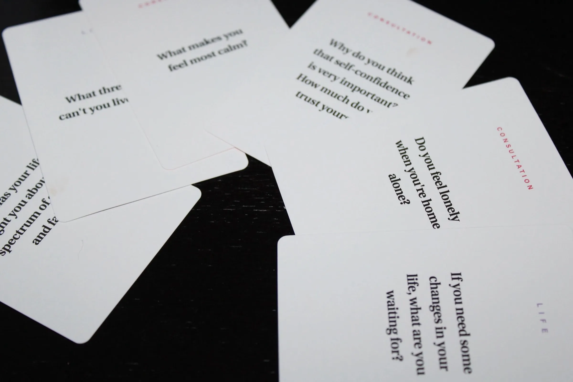 Conversation question cards spread across a dark table.