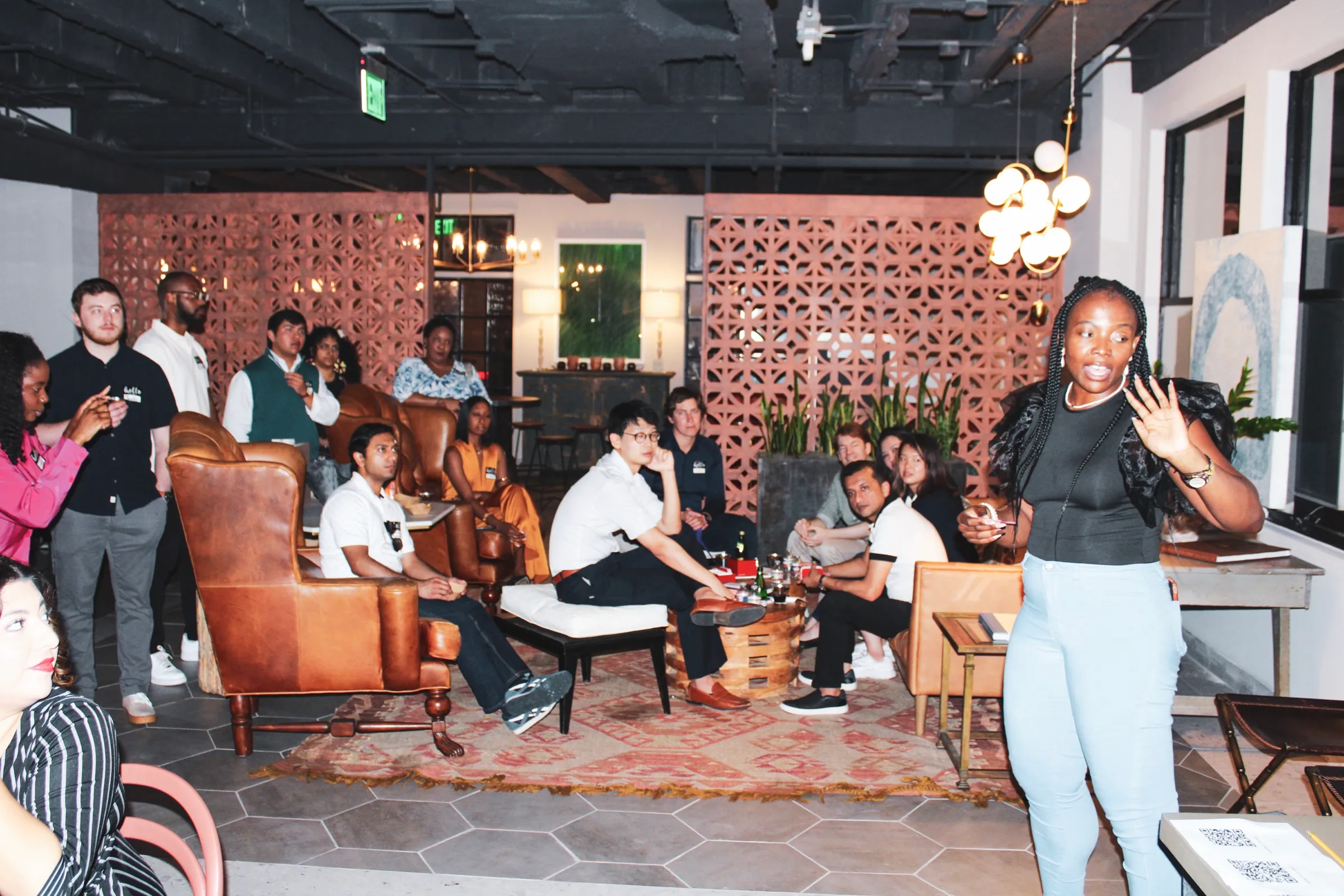 A packed lounge of members listening to a host.