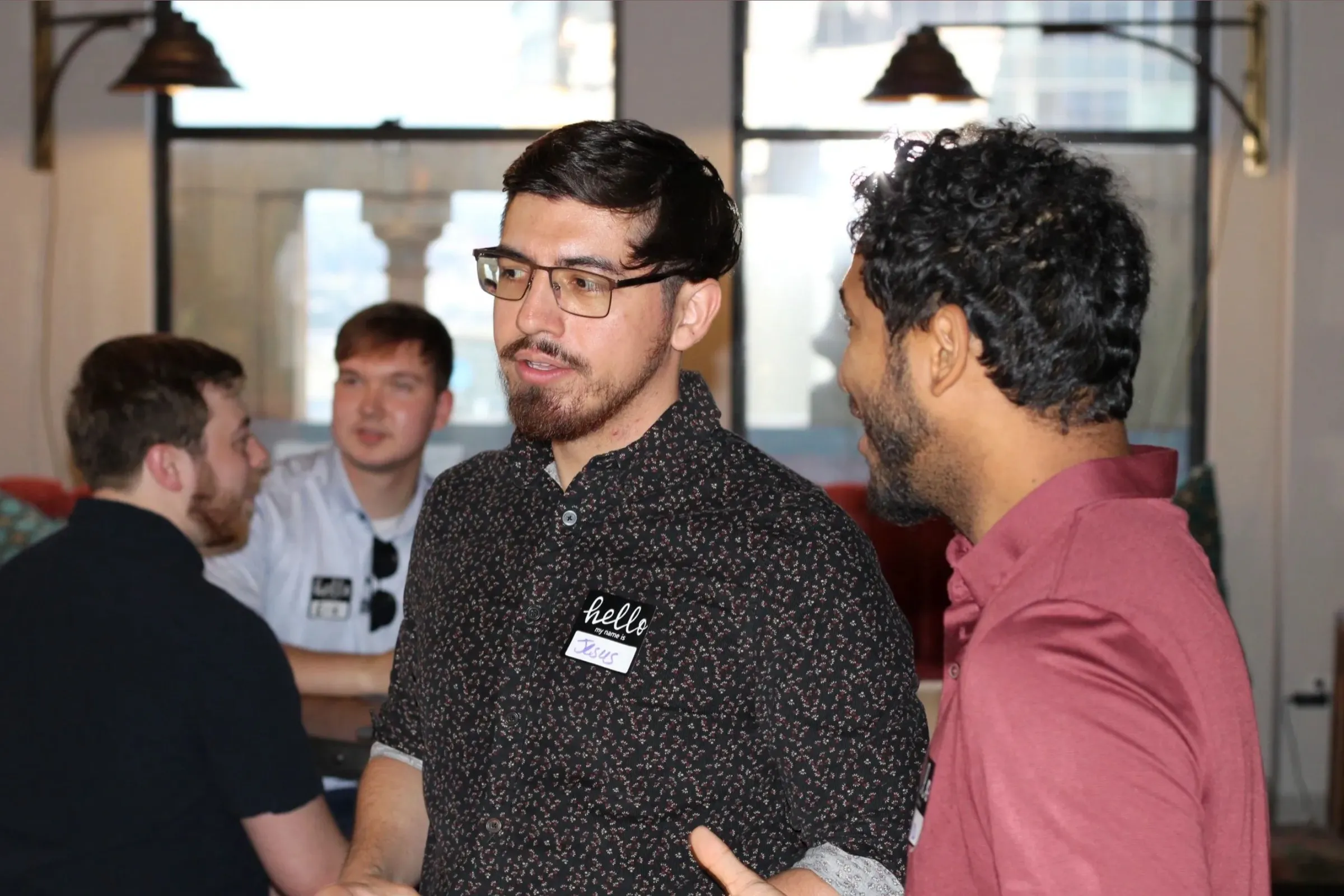 Three men in name tags deep in conversation.