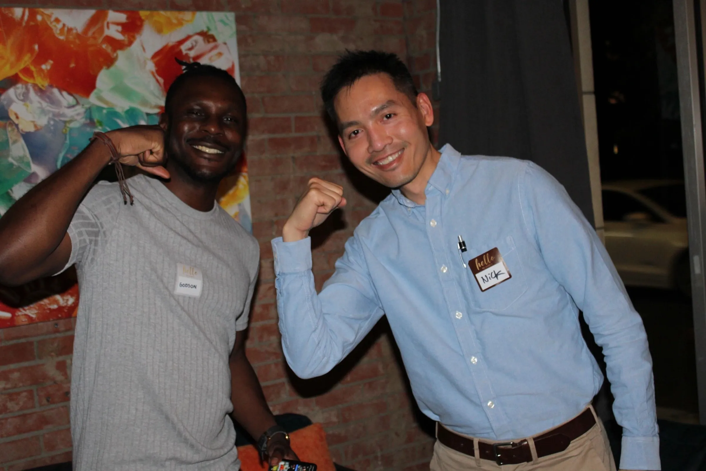 Two new friends in name tags flexing for the camera.